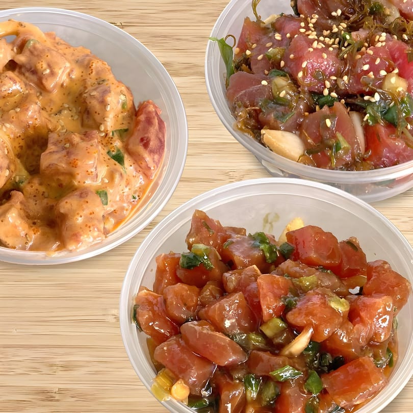 Three Poke Etc. poke bowls with different toppings, including spicy mayo and seaweed, on a wooden surface.